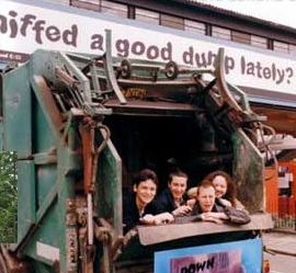 L'équipe de Down in the Dumps en 1996, photo promotionnelle dans une benne à ordures